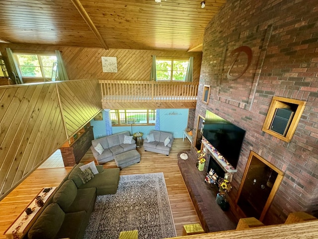 living room with hardwood / wood-style flooring, a healthy amount of sunlight, wooden walls, and wooden ceiling