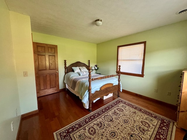 bedroom featuring dark wood-type flooring and a textured ceiling