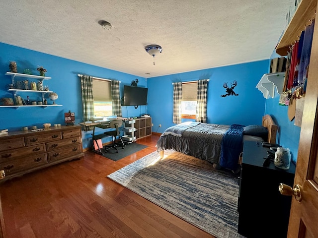 bedroom featuring hardwood / wood-style flooring and a textured ceiling