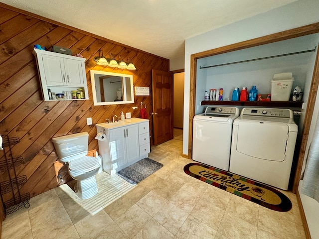 laundry room featuring wooden walls and independent washer and dryer