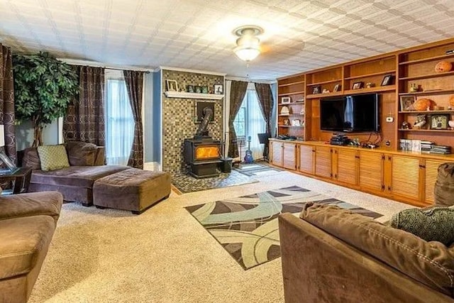 carpeted living room featuring a wood stove and built in features