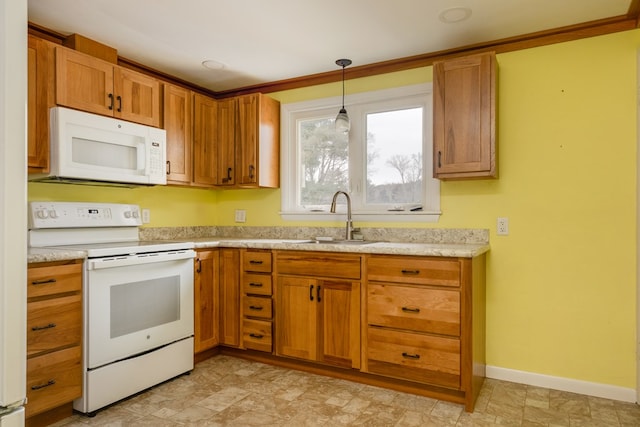 kitchen featuring sink, white appliances, and decorative light fixtures