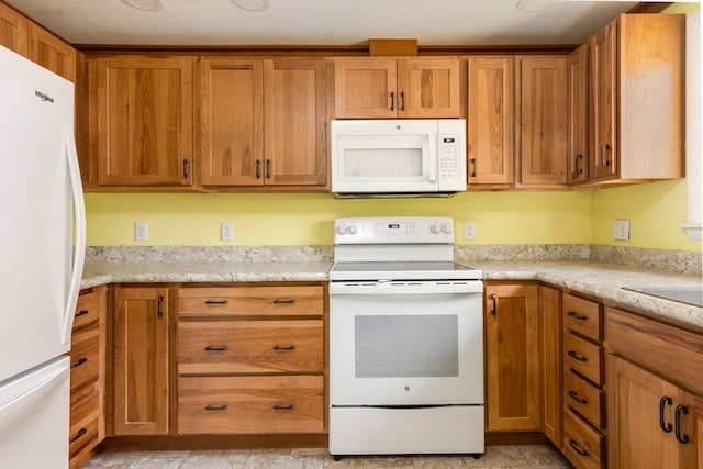 kitchen featuring white appliances and light stone countertops