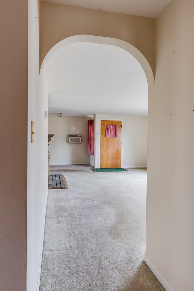 hallway featuring an AC wall unit and light carpet