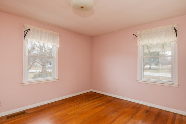 unfurnished room featuring hardwood / wood-style flooring and a wealth of natural light