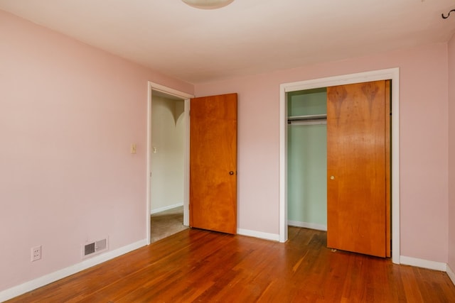 unfurnished bedroom featuring hardwood / wood-style floors and a closet