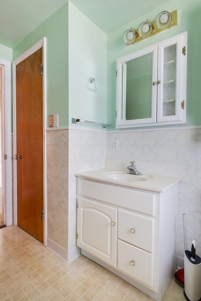 bathroom with vanity and tile walls