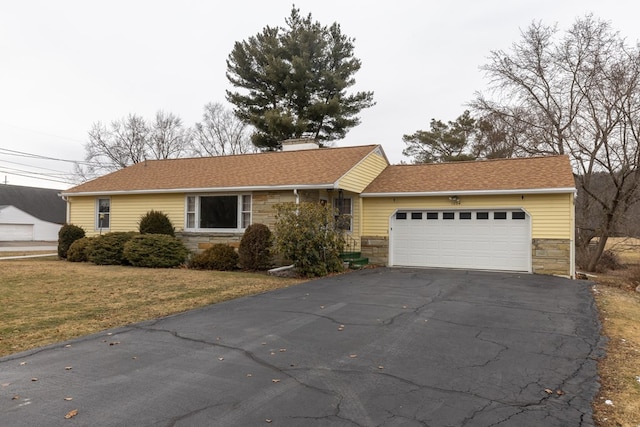 ranch-style house with a garage and a front lawn