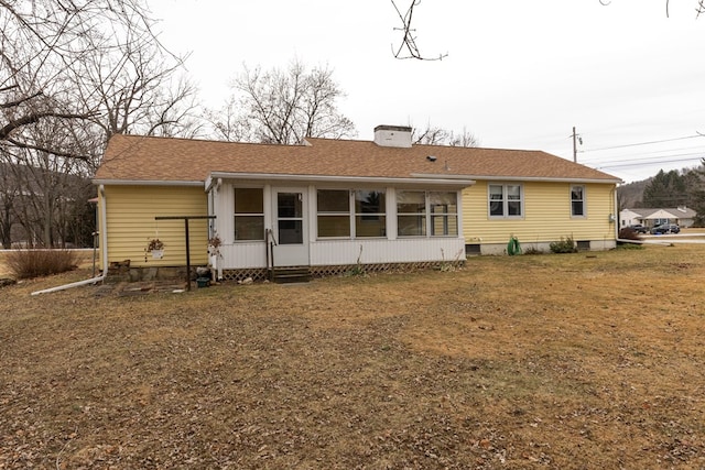 rear view of property with a lawn