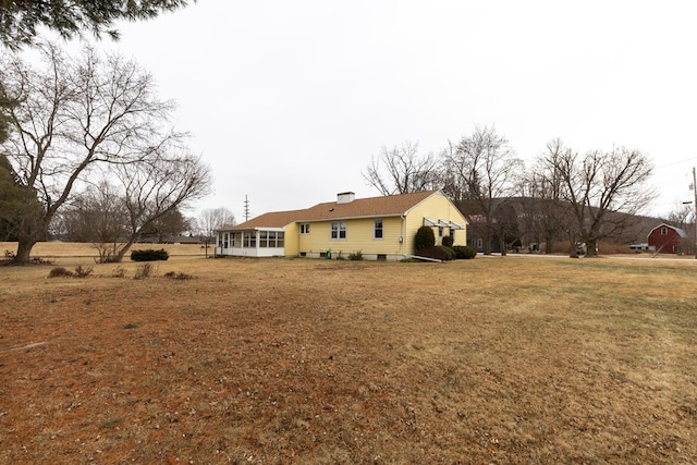 back of house with a sunroom and a yard