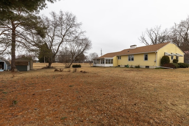 view of yard featuring a shed and a sunroom