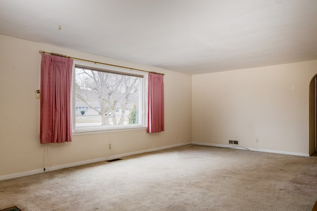 spare room featuring light carpet