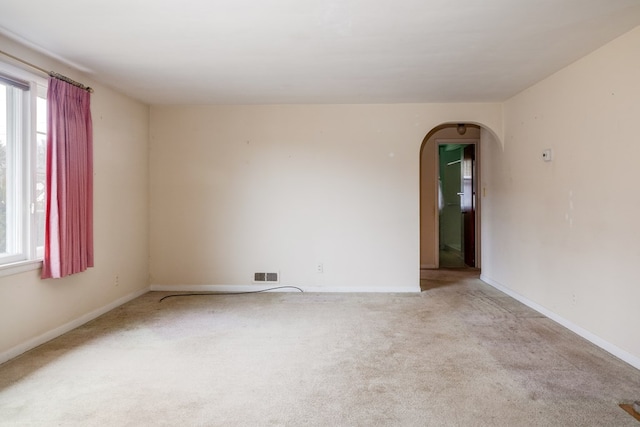 unfurnished room featuring a healthy amount of sunlight and light colored carpet