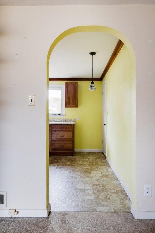 interior space with ornamental molding and light carpet