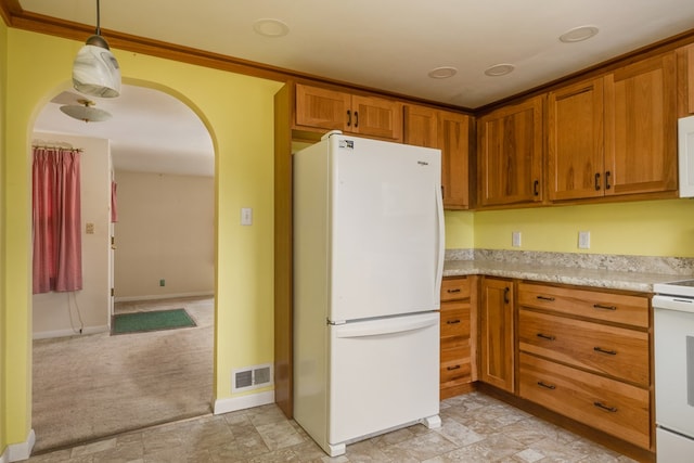 kitchen featuring light carpet, hanging light fixtures, and white appliances