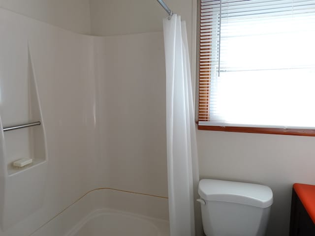 bathroom featuring toilet and a shower with shower curtain