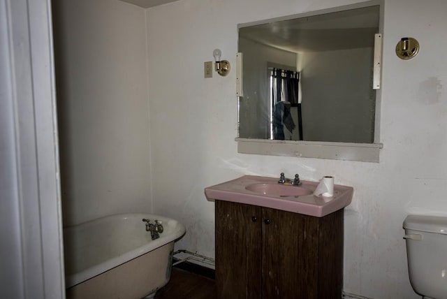 bathroom with vanity, toilet, and a bathing tub