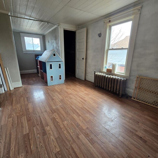 additional living space featuring radiator heating unit, hardwood / wood-style floors, and wooden ceiling