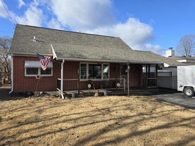 view of front of home with covered porch and a front lawn