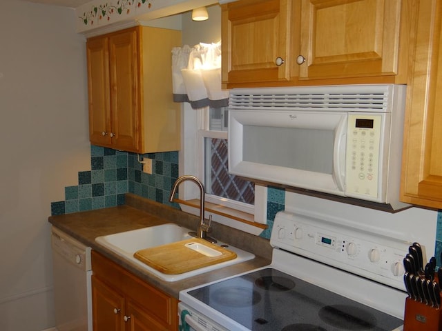 kitchen featuring sink, white appliances, and backsplash