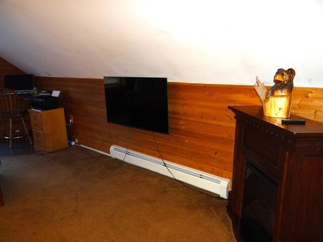 living room featuring dark colored carpet, wood walls, vaulted ceiling, and a baseboard heating unit