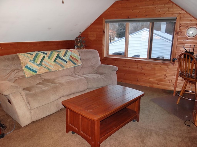 carpeted living room with lofted ceiling and wood walls