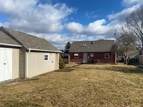 back of property featuring a yard