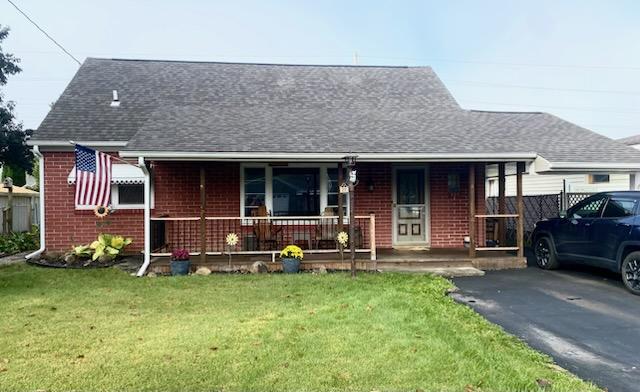 bungalow featuring covered porch and a front lawn