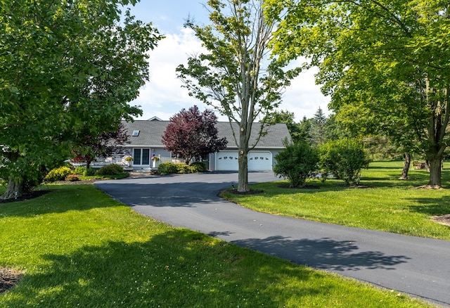 view of front of property with a garage and a front lawn