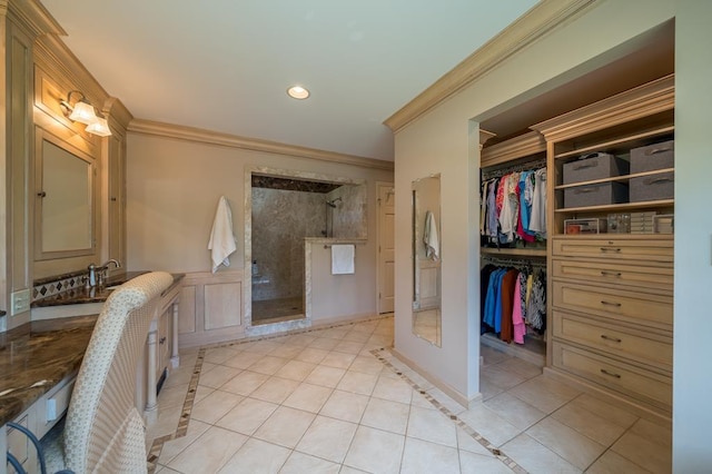 bathroom featuring tile patterned flooring, ornamental molding, and a tile shower