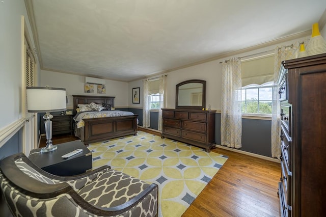 bedroom with multiple windows, a wall mounted air conditioner, crown molding, and light wood-type flooring