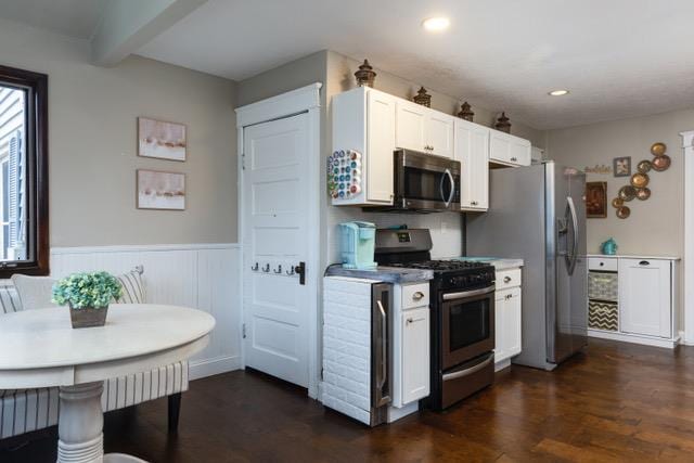 kitchen featuring white cabinetry, stainless steel appliances, dark hardwood / wood-style floors, a healthy amount of sunlight, and beamed ceiling