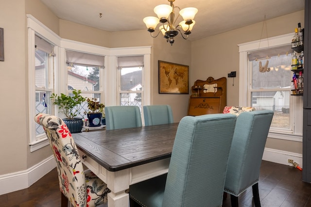 dining area featuring an inviting chandelier and dark wood-type flooring