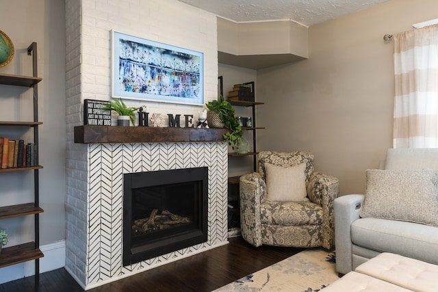 living room featuring dark hardwood / wood-style floors, a fireplace, and a textured ceiling