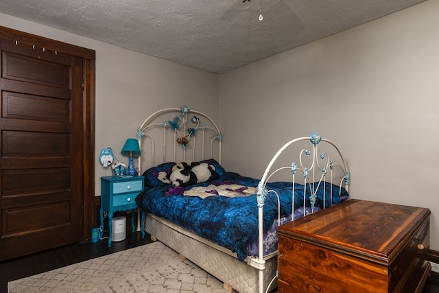 bedroom with dark hardwood / wood-style flooring and a textured ceiling