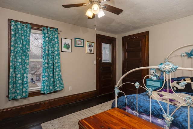 bedroom featuring ceiling fan, hardwood / wood-style floors, and a textured ceiling