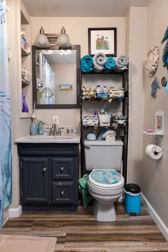 bathroom with vanity, wood-type flooring, and toilet