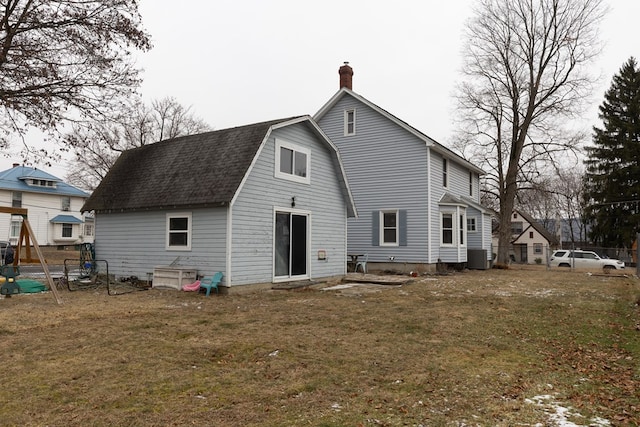 back of property with cooling unit and a lawn