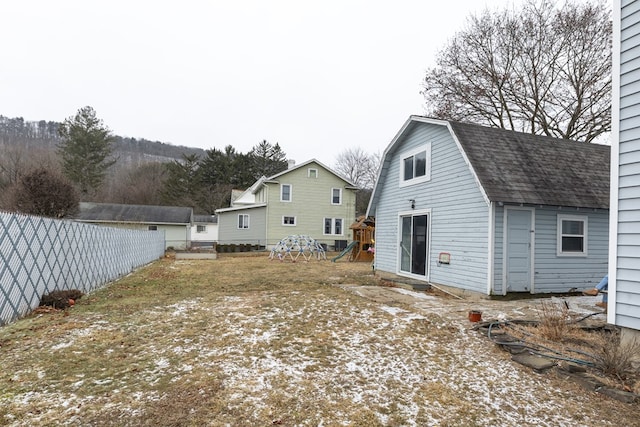 rear view of house featuring a playground