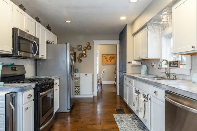 kitchen featuring stainless steel appliances, sink, white cabinets, and dark hardwood / wood-style flooring