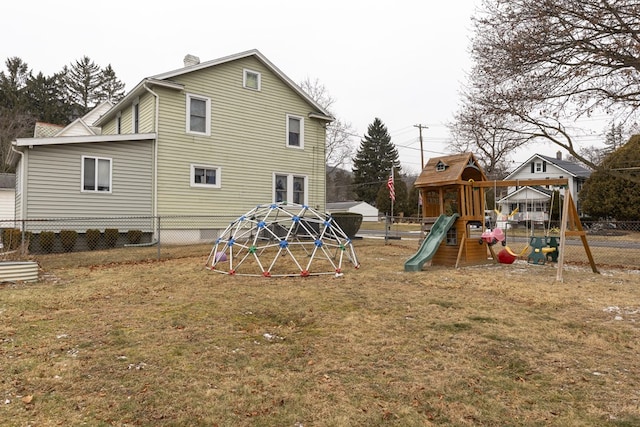 rear view of house with a yard and a playground