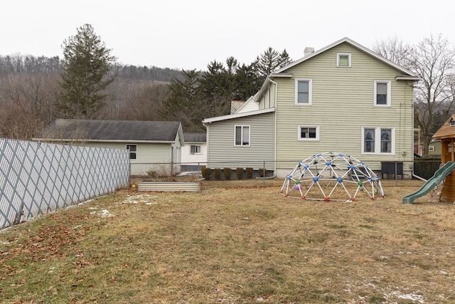 back of house with a yard and a playground