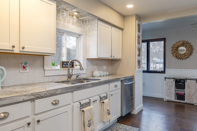 kitchen with sink, light stone counters, dark hardwood / wood-style flooring, dishwasher, and white cabinets