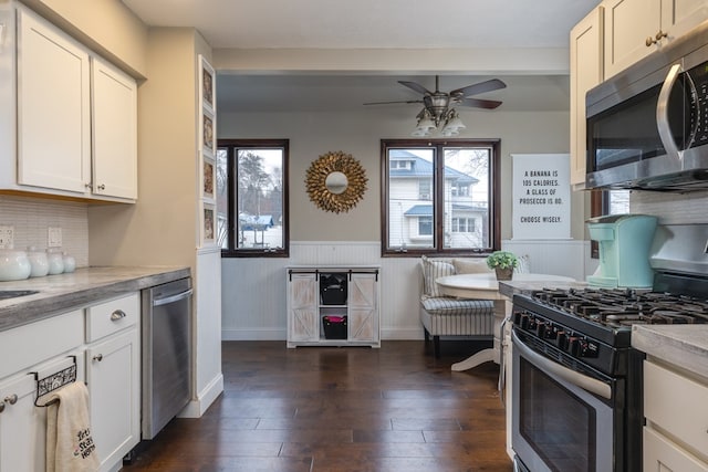 kitchen featuring white cabinetry, stainless steel appliances, dark hardwood / wood-style floors, and ceiling fan