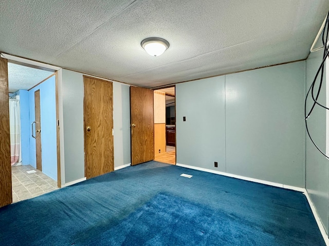 unfurnished bedroom with light colored carpet and a textured ceiling