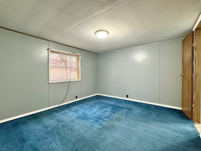 carpeted spare room with a textured ceiling