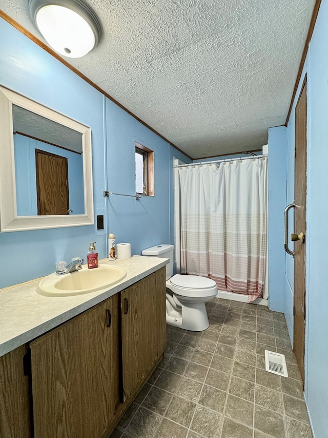 bathroom featuring ornamental molding, vanity, toilet, and a textured ceiling