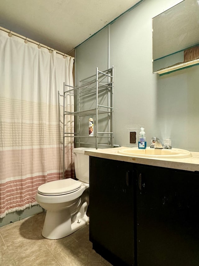 bathroom with vanity, tile patterned floors, toilet, and walk in shower