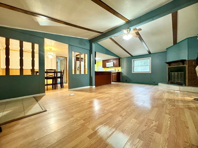 living room featuring ceiling fan, lofted ceiling with beams, and light wood-type flooring