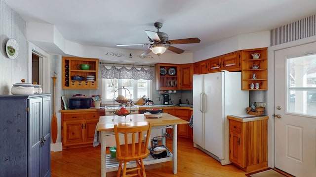 kitchen featuring light wood-type flooring, ceiling fan, and white fridge